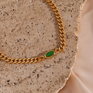 Detailed close-up of 6.3mm gold-plated Cuban chain necklace with a green oval pendant