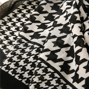 Close-up of soft houndstooth scarf showing fine woven texture and detailed fabric draping