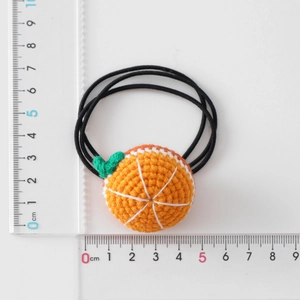 Handmade crochet orange fruit hair tie for girls with measurements on white background