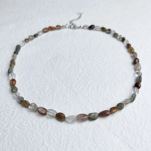 Natural irregular gemstone beads necklace with stainless steel clasp on white background