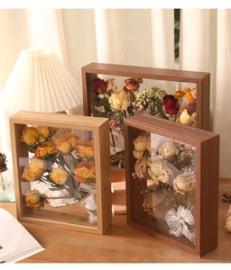 Macro view of handmade wooden shadow box frames with dried flower bouquets inside