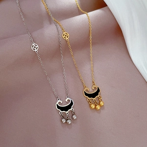 Detailed view of gold and silver coin lock necklaces with bells on pink fabric