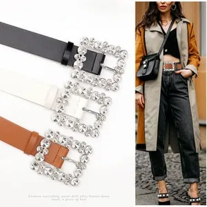 Detail of western style belt with large rhinestone square buckle and stone pattern texture