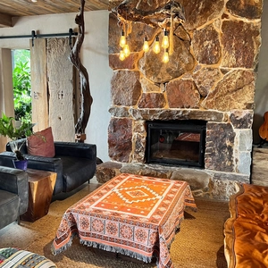 Bohemian orange geometric throw blanket with fringe tassels in a cozy living room setting
