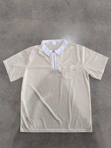 Detail eines beigen Herren-Poloshirts mit weißem Kragen, Reißverschluss und Brusttasche