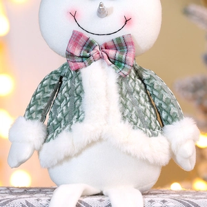 Detailed view of plush snowman ornament with green textured coat and red plaid bow