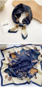 Navy and beige silk-feel square scarf with vintage chain print on a wooden tray