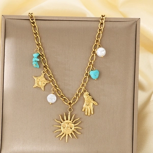 Detail of gold sun and moon pendant necklace with pearls and turquoise stone accents