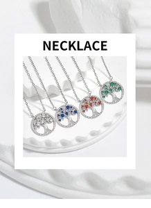 Close-up of four tree of life necklaces with colorful zircon leaves on a white stand