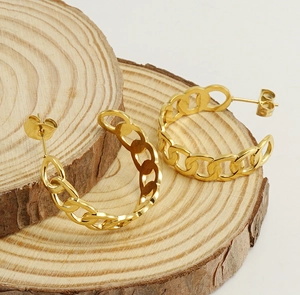 Detailed macro view of 18K gold plated interlocking link hoop earrings on wood background