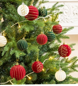 Close-up of velvet Christmas ornaments with gold leaf patterns on a festive tree