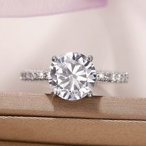 Macro shot of a four-prong zircon engagement ring with a diamond-encrusted silver band
