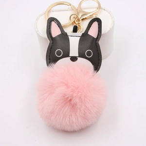 Bulldog bag charm with a large pink pompom and golden keyring on a white display