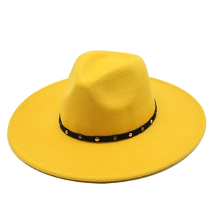 Detail of bright yellow wool fedora hat with black studded band and wide brim