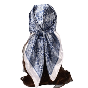 Detail of blue and white paisley silk scarf tied as a stylish headband accessory