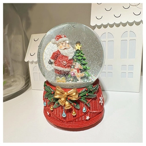 Detail of Christmas snow globe with Santa and dog inside a red woven textured resin base