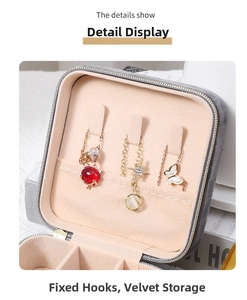 Detail of grey velvet jewelry box featuring necklace hooks and portable zipper storage