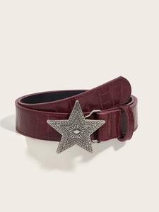 Close-up of vintage engraved star buckle on burgundy crocodile embossed belt