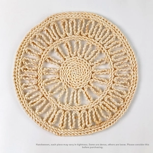 Detail view of a handcrafted woven corn husk placemat with a spiral pattern