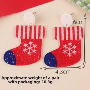 Detailed view of red acrylic Christmas stocking earrings with glitter and snow patterns