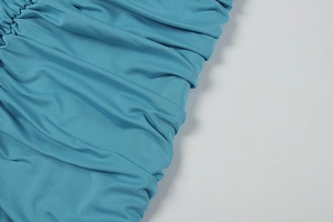 Gros plan détaillé sur le tissu bleu sarcelle avec fronces et plis soyeux élégants