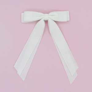 Detail of white velvet double-layered bow hair clip with long elegant ribbons