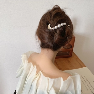 Close-up of elegant pearl hair clip worn on a French twist hairstyle for women