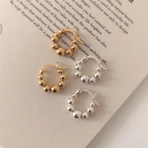 Detail of S925 sterling silver beaded hoop earrings in gold and silver finish