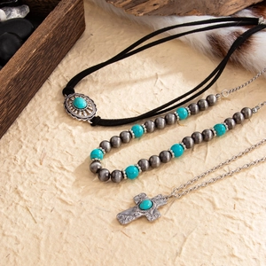 Detail of bohemian turquoise sun flower necklace with cross pendant and beaded jewelry layers