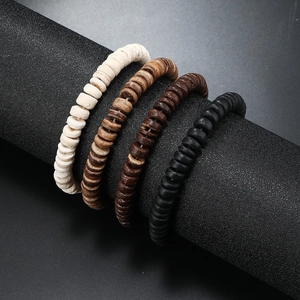 Detail of multi-color wooden bead bracelets showing natural textures on black display