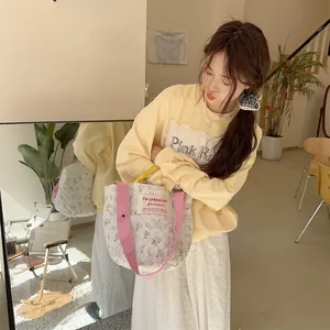 Détail du sac seau matelassé à fleurs avec anses roses et imprimé lapin mignon