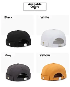 Detail view of four brimless docker hats in black, white, gray, and yellow with leaf accents