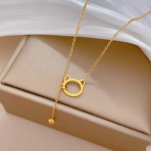 Close-up of golden cat pendant and bead necklace on white silk in a jewelry gift box