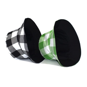 Detail of reversible plaid bucket hats in black-white and green-white canvas fabric