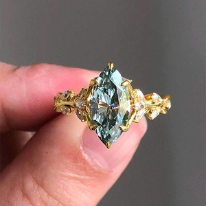 Macro detail of leaf vine ring featuring marquise-cut turquoise zircon in gold setting