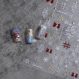 Christmas nail stickers with snowflake patterns and bow designs on grey stone background