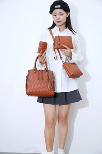 Detail of brown woven texture handbag set with four pieces and tassel accent