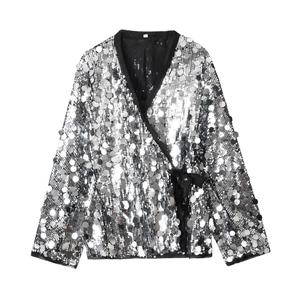 Detail of silver sequin wrap blouse with V-neckline and black waist tie closure