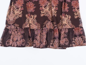 Detailed macro view of bohemian paisley print chiffon maxi dress hem with ruffle edges