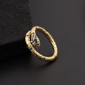 Close-up of golden snake ring featuring blue zircon eyes and detailed scale texture