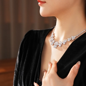 Elegant model wearing silver floral necklace with zircon droplets and sparkling diamonds
