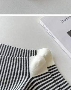 Detail von schwarz-weiß gestreiften Baumwollsocken mit verstärktem weißem Fersenbereich
