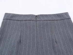 Détail du short gris à fines rayures montrant la fermeture éclair invisible et le tissu
