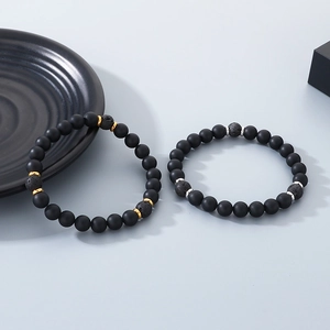 Detailed close-up of matte black onyx beads and lava rock bracelets with metallic accents