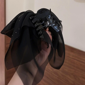 Detail of black chiffon bow hair claw clip with subtle sparkling diamond accents