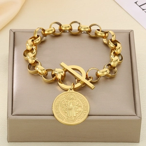 Gros plan sur un bracelet chaîne doré avec pendentif rond et fermoir OT sur un présentoir