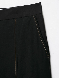 Detail of high-quality black twill trousers featuring golden brown contrast stitching