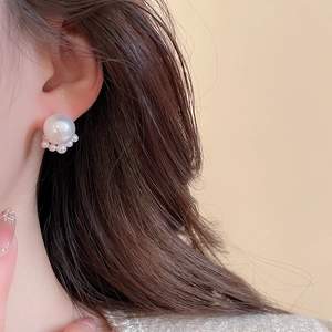 Close-up of pearl cluster earrings with elegant fanned design on model ear