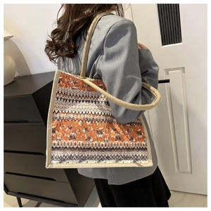 Ethnic print canvas shoulder bag with rope handles shown being worn by a model