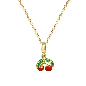 Détail du collier doré avec pendentif cerise rouge et feuilles en émail vert
